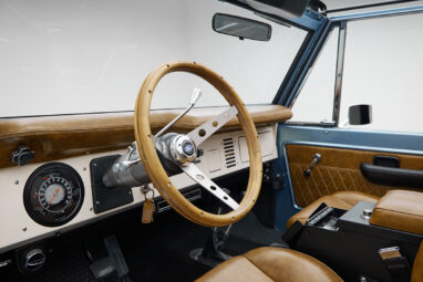1973 Ford Bronco in Brittany Blue over Whiskey leather steering wheel