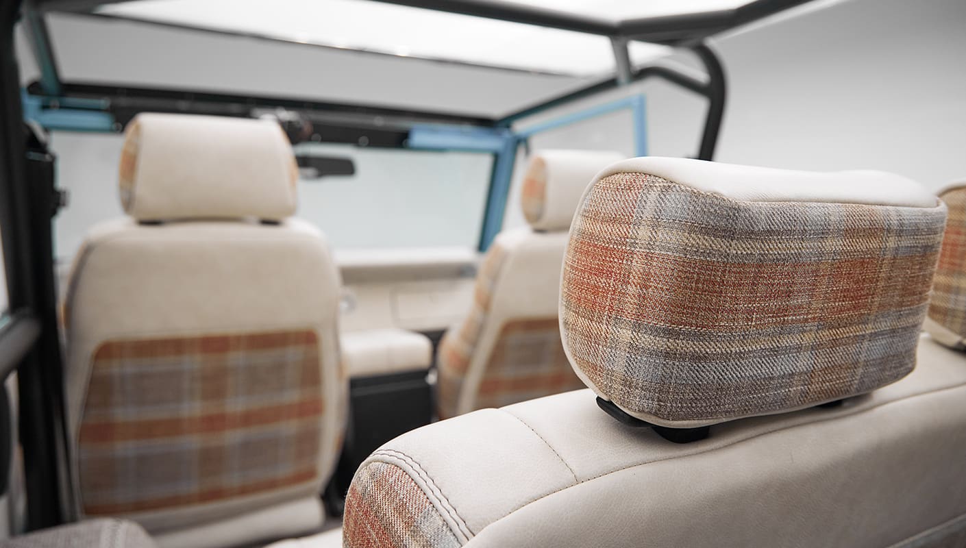 A 1970 Classic Ford Broncos coyote series in frozen blue over custom white rock leather with tartan plaid interior and family cage 2 backseat headrests