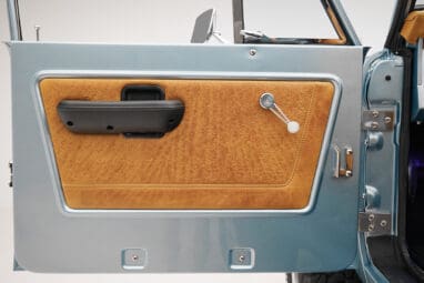 1975 ford bronco painted brittany blue with cowboy debossed, baseball stitch leather detail door panel