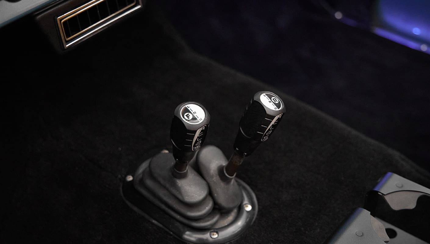 1975 ford bronco painted brittany blue with cowboy debossed, baseball stitch leather transfer case levers