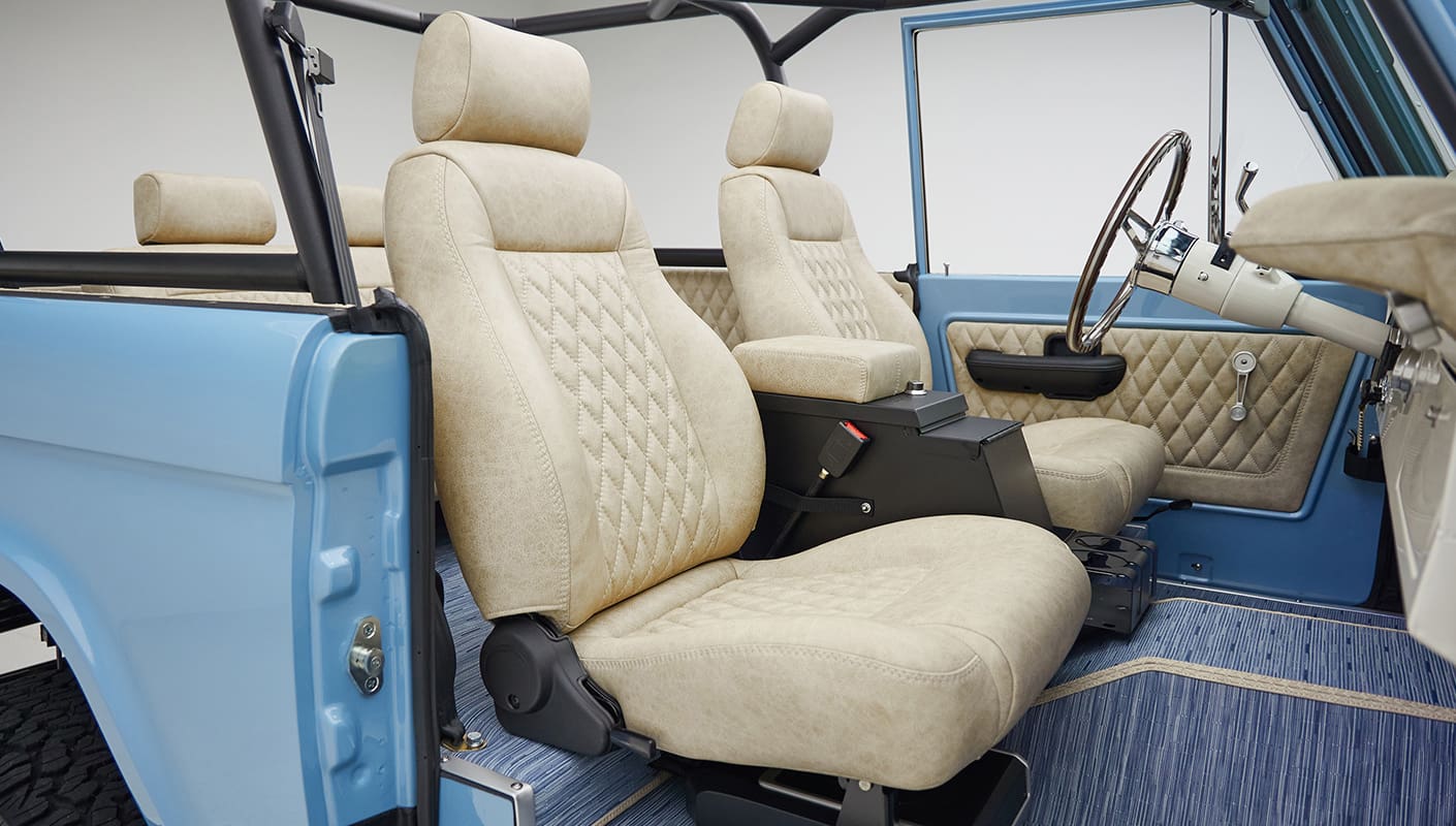 A 1976 Classic Ford Bronco is Frozen Blue over White Rock leather passenger seat