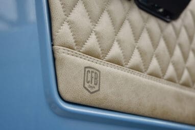 A 1976 Classic Ford Bronco is Frozen Blue over White Rock leather custom leather door panel