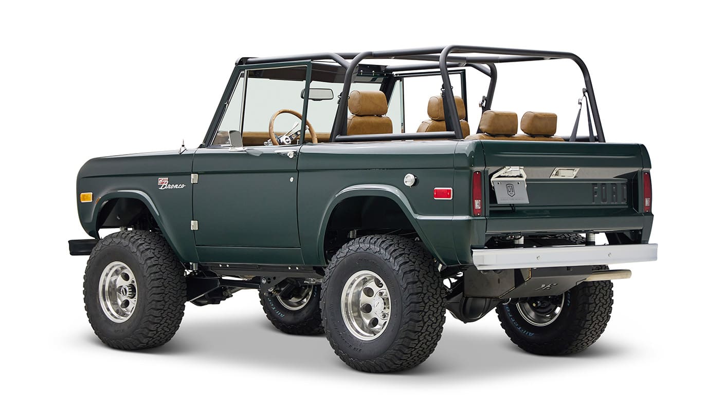 1966 ford bronco in highland green with whiskey leather interior rear driver angle