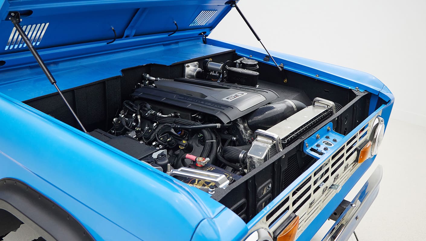 1976 classic ford bronco in blue patina paint with whiskey leather interior motor angle