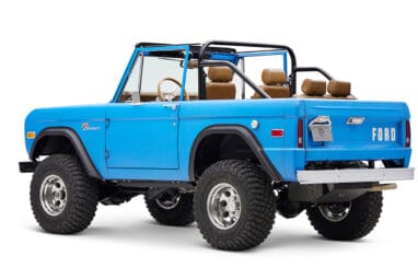 1976 classic ford bronco in blue patina paint with whiskey leather interior driver rear angle