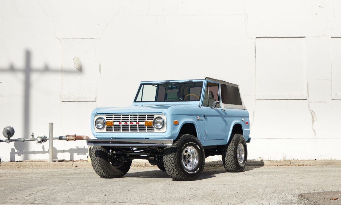 A fully restored 1968 Classic Ford Bronco “Montecito” parked on a clean urban street, displaying its open-top cabin, premium interior details, and modern drivetrain while retaining vintage SUV proportions. Built by Classic Ford Broncos, this custom 4×4 combines classic truck heritage with contemporary performance and refined design.