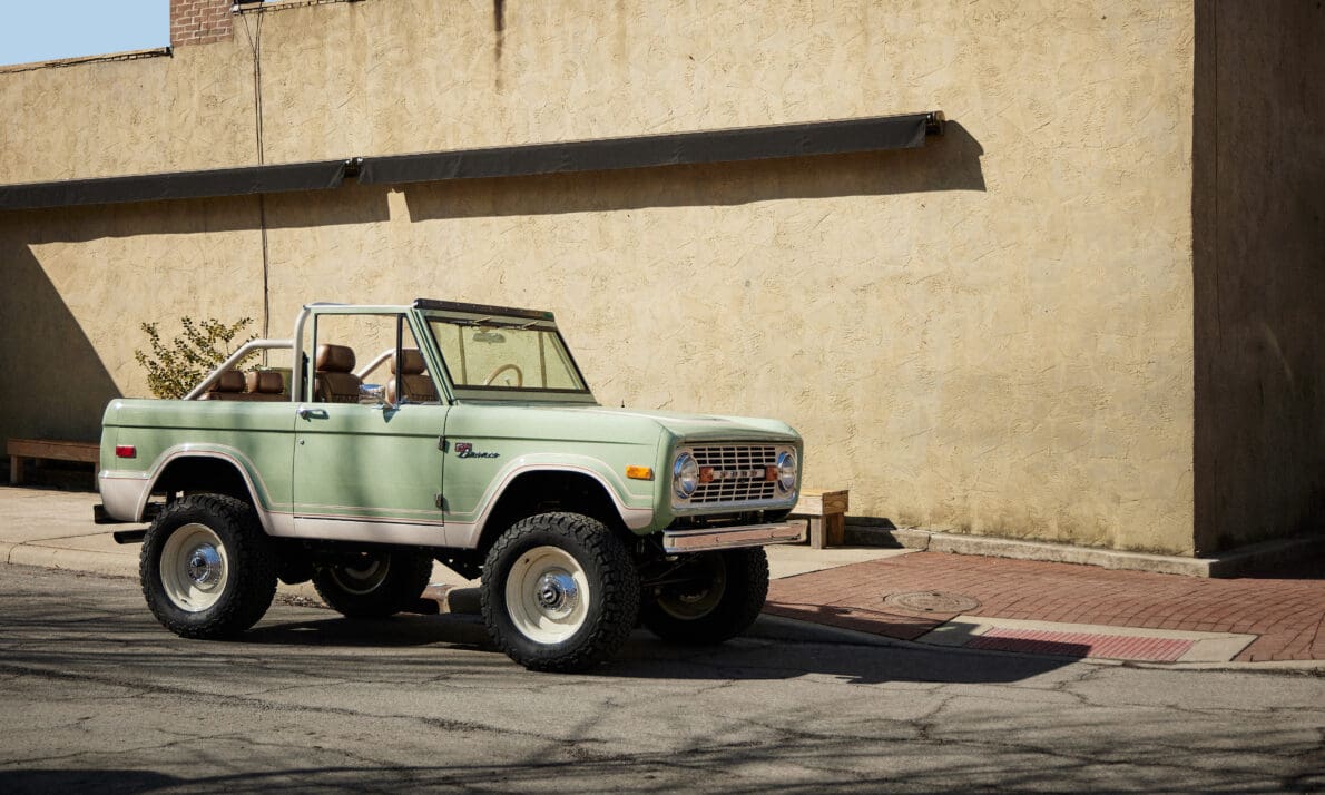 A fully restored 1971 Classic Ford Bronco named “Duval St” is parked along a quiet city street with the top off, showcasing its handcrafted details and refined interior. Built by Classic Ford Broncos, this vintage SUV captures timeless design and exceptional craftsmanship.